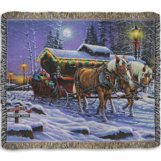 A woven throw blanket printed with a painting of people on a horse-drawn sleigh ride around a lake during Christmas.