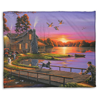 A coral fleece blanket designed with a painting of a soldier returning home to his house on the lake, being greeted by his family and dogs. Geese fly overhead into the sunset. 