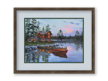 A painting of a lakeside cabin, with a boat out on the water and geese overhead. Printed on paper, matted, and framed.