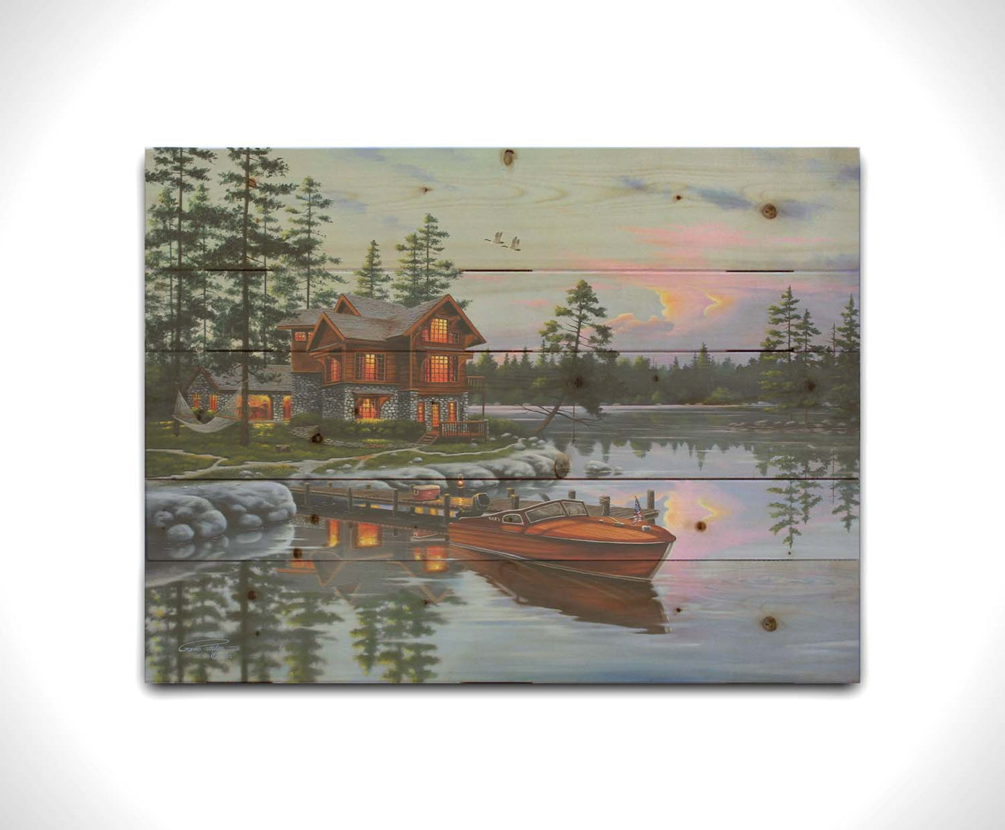 A painting of a lakeside cabin, with a boat out on the water and geese overhead. Printed on a wood pallet.