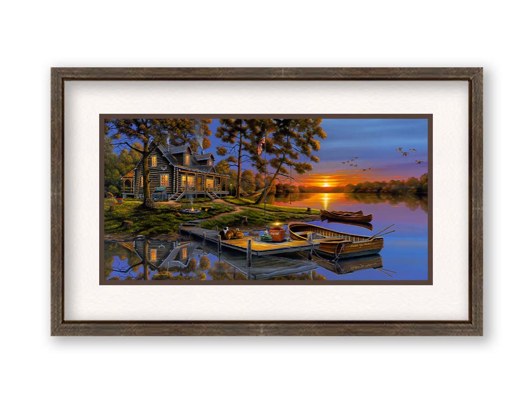 A painting of an American lakeside cabin at sunset, with boats on the water and geese overhead. Printed on paper, matted, and framed.