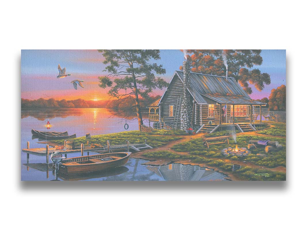 A painting of a lakeside cabin in a deciduous forest of the United States. The sunset is reflected by the water, where several small boats are docked. A lit campfire, deer, geese, and dog bring extra life to the scene. Printed on canvas.