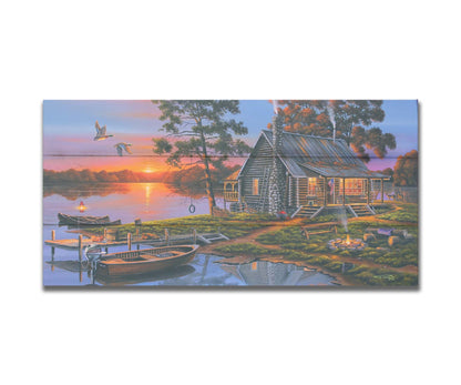 A painting of a lakeside cabin in a deciduous forest of the United States. The sunset is reflected by the water, where several small boats are docked. A lit campfire, deer, geese, and dog bring extra life to the scene. Printed on a box board.