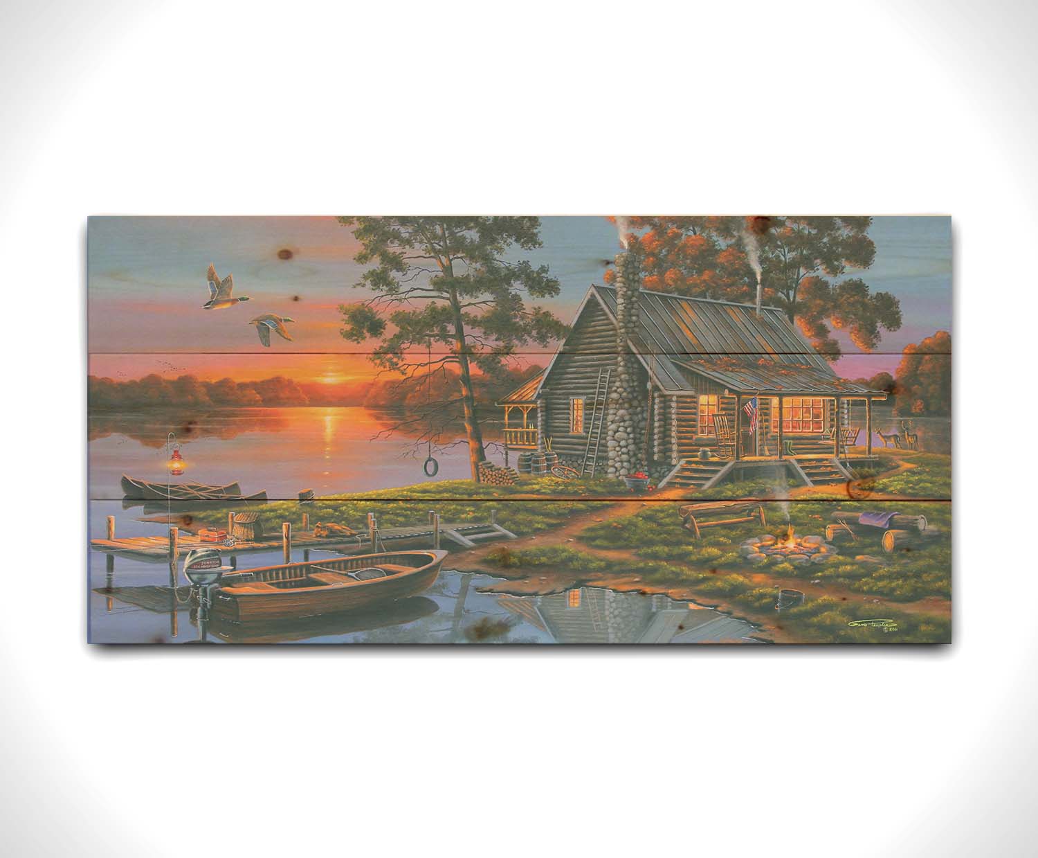 A painting of a lakeside cabin in a deciduous forest of the United States. The sunset is reflected by the water, where several small boats are docked. A lit campfire, deer, geese, and dog bring extra life to the scene. Printed on a wood pallet.