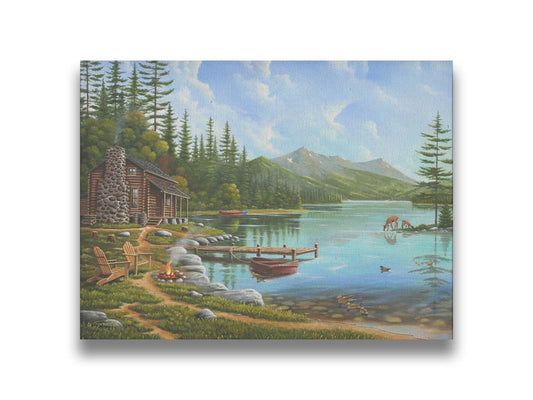 A painting of a lakeside cabin on a sunny day. Boats can be seen on the water, which reflects the mountains in the distance. Deer drink from the lake, where ducks are swimming. Wood chairs surround a small campfire on the shore nearby. Printed on canvas.