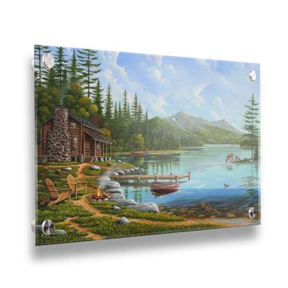 A painting of a lakeside cabin on a sunny day. Boats can be seen on the water, which reflects the mountains in the distance. Deer drink from the lake, where ducks are swimming. Wood chairs surround a small campfire on the shore nearby. Printed on acrylic.