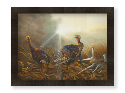 A portrait painting of two turkeys standing in a serene meadow, among fallen brown oak leaves and a shed deer antler. Printed on canvas and framed.