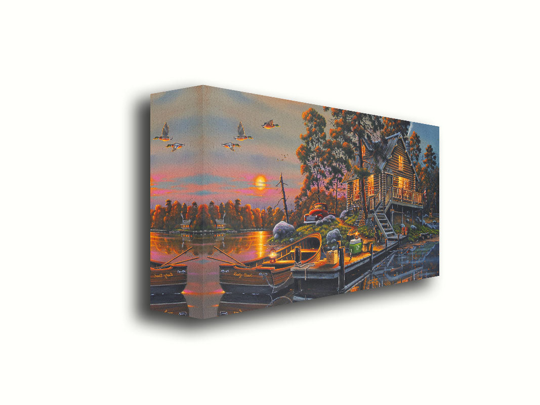 A painting of a lakeside cabin with a nearby dock. A fishing boat is tied up, and supplies are nearby to go fishing. The sunset is reflecting off the water. Printed on canvas.