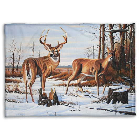 Coral fleece blanket designed with deer walking through the snow between the woods and a field.