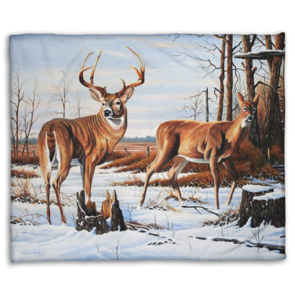 Coral fleece blanket designed with deer walking through the snow between the woods and a field.