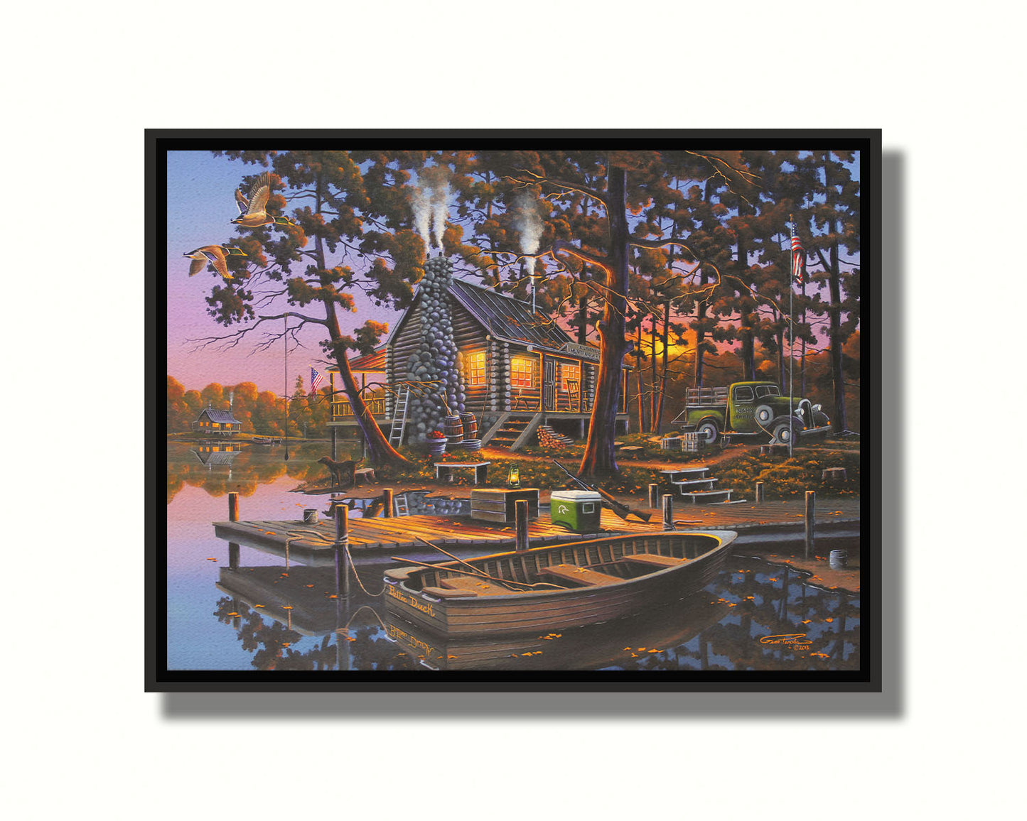 A painting of a lakeside log cabin hunting lodge at sunset. A rowboat is tied to the nearby dock, where shotguns are leaned against a cooler. Printed on canvas in a float frame.