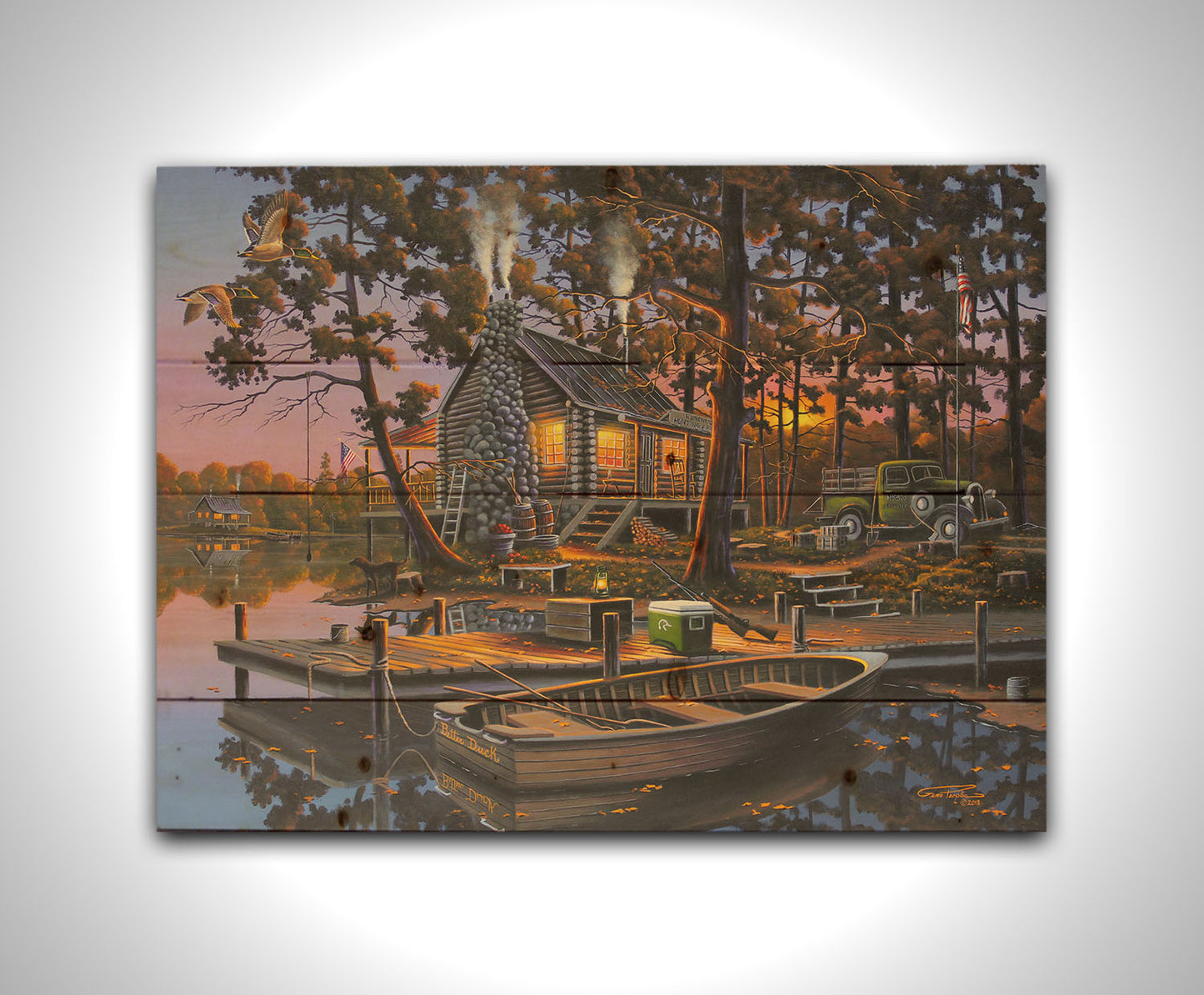 A painting of a lakeside log cabin hunting lodge at sunset. A rowboat is tied to the nearby dock, where shotguns are leaned against a cooler. Printed on a wood pallet.