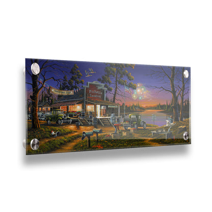 A landscape painting of a lakeside café at sunset, overlooking a colorful fireworks display over the lake on Veterans Day. People sit in the grass watching the excitement. Printed on acrylic.