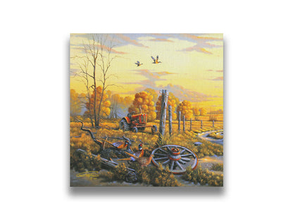 A landscape painting of autumn trees and a field. A tractor, a broken wheel, and a broken fence post add extra character to the scene. Pheasants sit in the foreground and ducks fly overhead. The sky and field are as golden yellow as the trees, in the morning light. Printed on canvas.