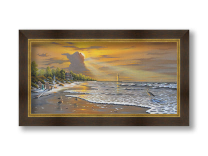 A painting of a beach scene, with a house and lighthouse in the distance. Birds trot along the sand, and the sun peeks from behind a cloud, shining beams of light down on them. Printed on canvas and framed.