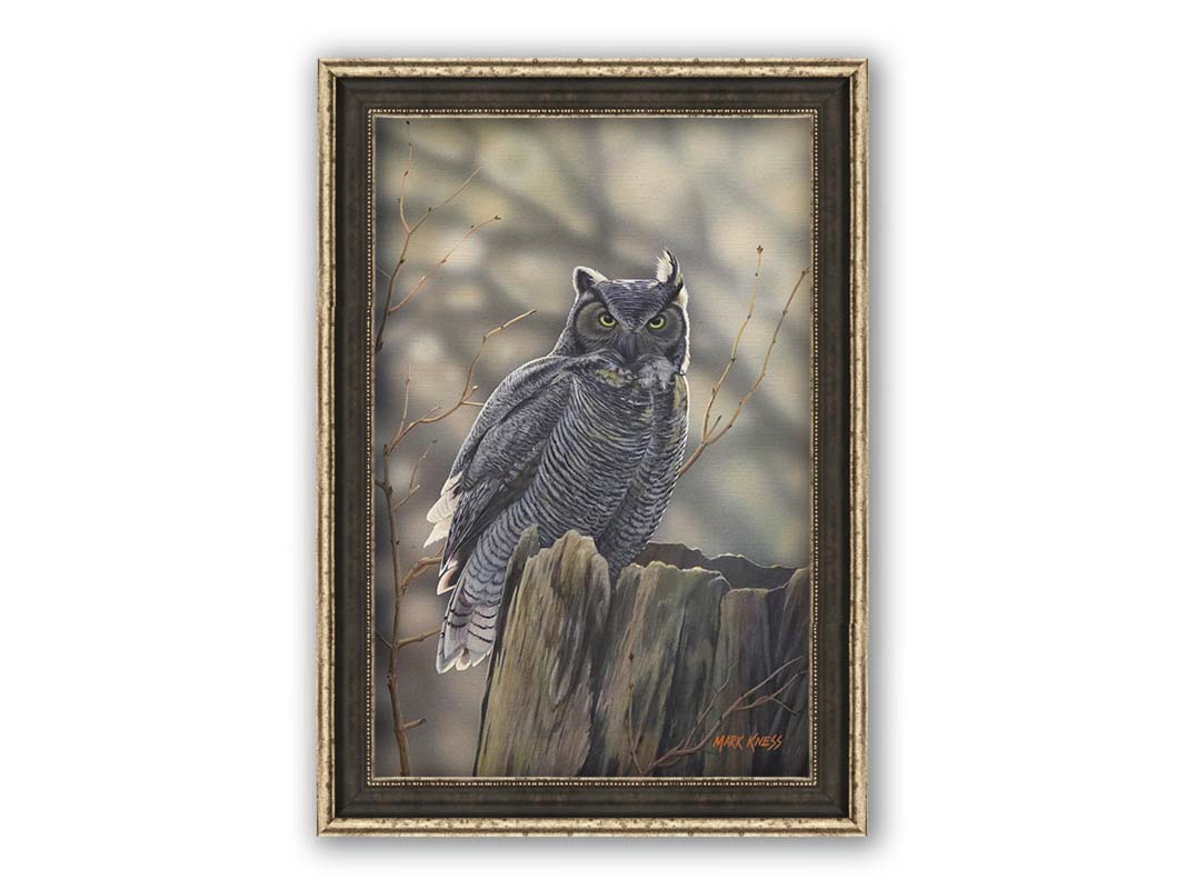 A painting of a great horned owl perched atop a log. Printed on canvas and framed.