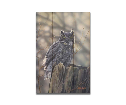 A painting of a great horned owl perched atop a log. Printed on a box board.