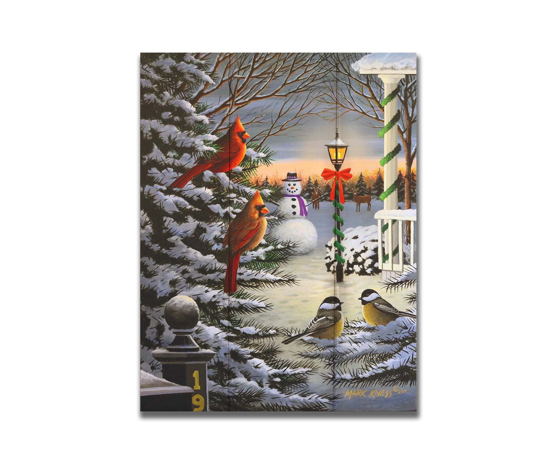 A painting of cardinals and chickadees perched on snowy evergreen branches. In the background, a festively decorated streetlamp illuminates a nearby snowman. Deer look on in the distance. Printed on a box board.