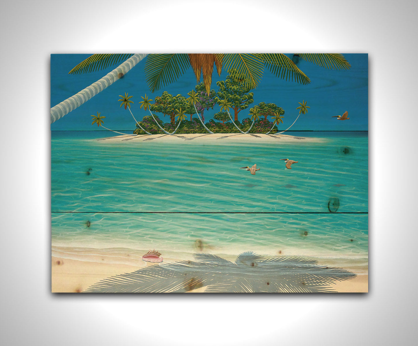 A painting of a beach scene, looking out over the sea toward an island. Palm trees grow reaching out over the ocean, and three pelicans fly low over the water. Printed on a wood pallet.