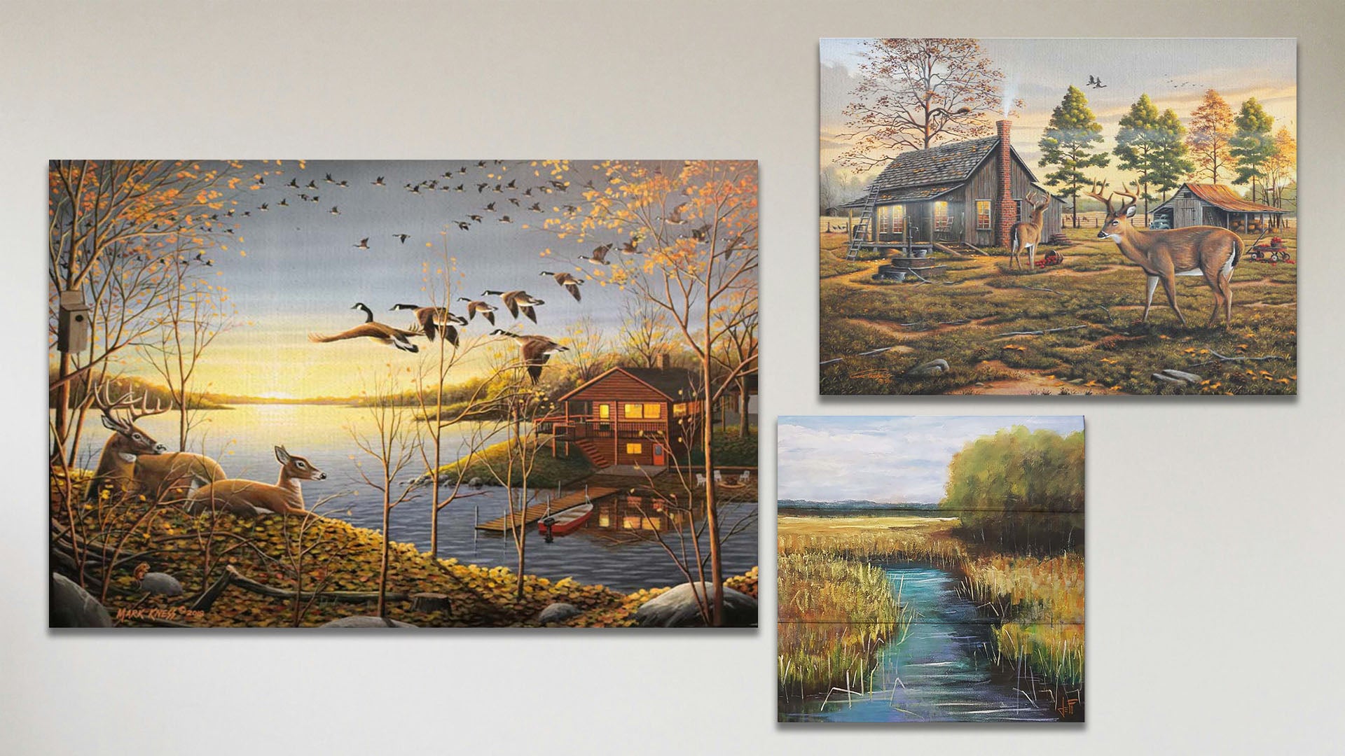 A collage of art in the standard Dream Cabin package, including a box board painting of a stream through a grassy field and two canvas paintings of a woodsy cabin landscaped.