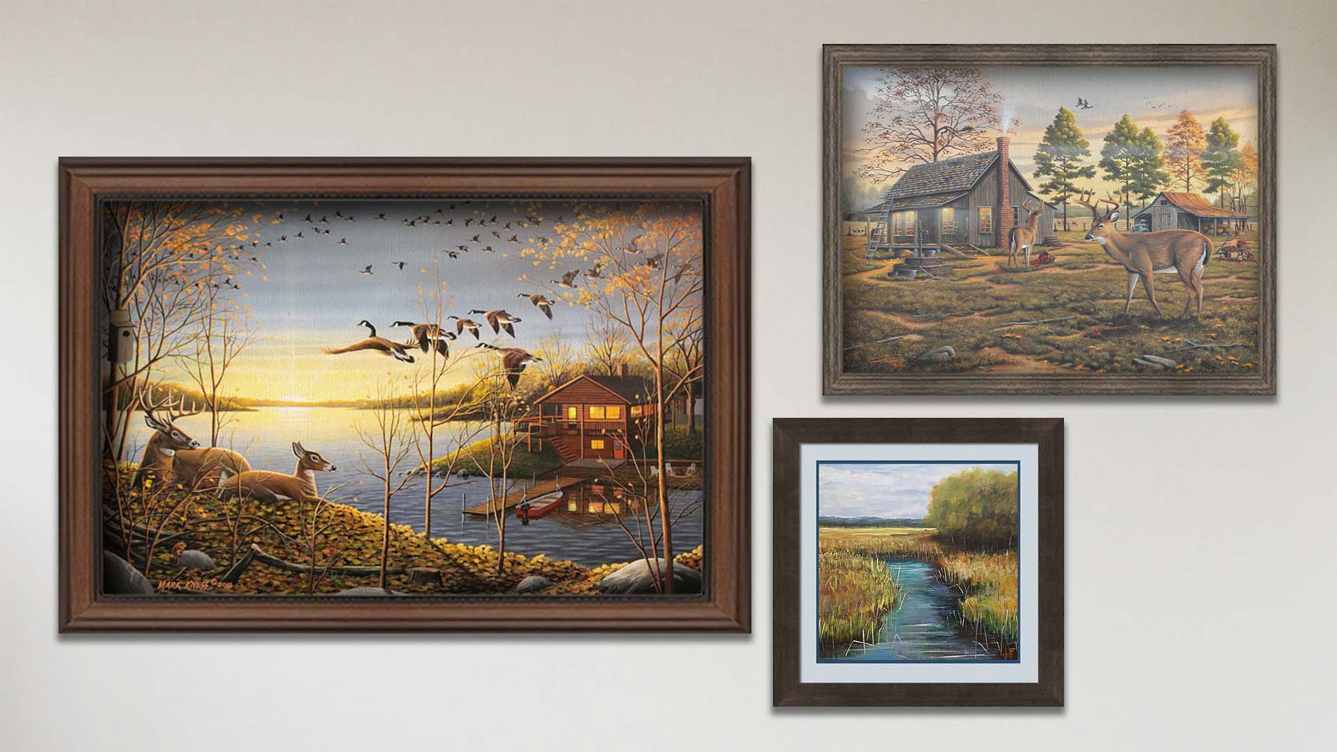 A collage of art in the designer Dream Cabin package, including a matted and framed painting of a stream through a grassy field and two framed paintings of a woodsy cabin landscaped.