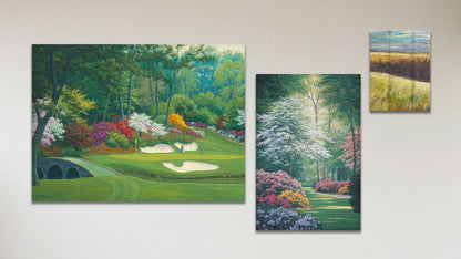 A collage of art in the standard 12th Hole at Augusta package, including a canvas painting of Augusta National golf course, a canvas painting of a garden clearing with a gazebo, and a box board painting of a meadow landscape.