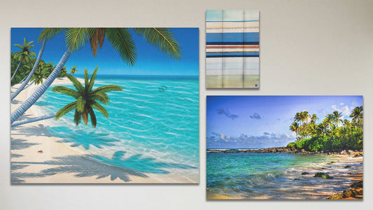 A collage of art in the standard Barefoot Beach package, including a canvas painting of a vibrant tropical beach, a canvas photograph of Laniākea beach (nicknamed Turtle Beach) on Oʻahu, Hawaiʻi, and a box board abstract geometric painting invoking boats, the shore, and sea.