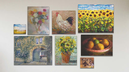 A collage of art in the standard Bird Food package, including five canvas paintings of a sunflower field, a rooster, a pot of sunflowers, a vase of carnation flowers, and a courtyard garden; a canvas photo of a bowl of fruit; a box board painting of two terriers with a tennis ball; and a box board photo of a barn and sky overlaid with the words "I love this life".