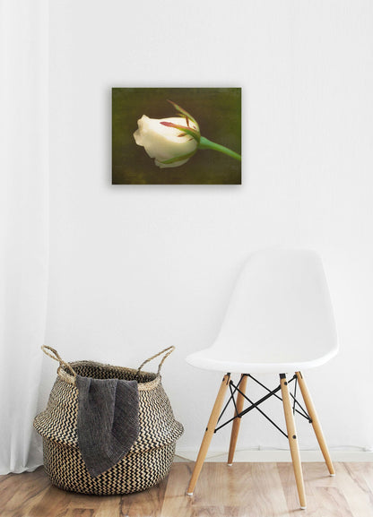 A white room with wood accents and a woven basket. A canvas painting of a white rose hangs on the wall.