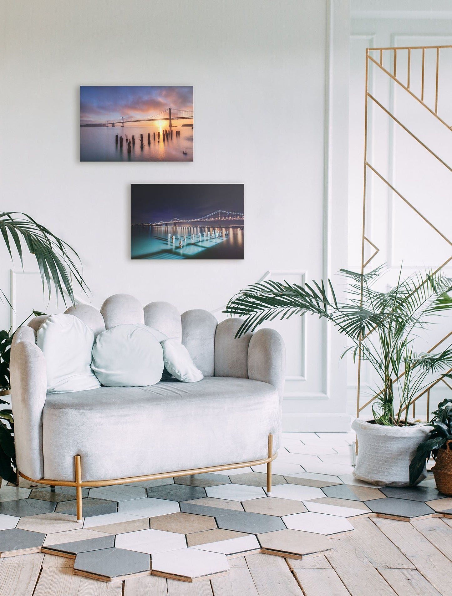 A tropical sea themed living room with palm plants and shell-themed furniture. Two canvas photographs overlooking the bridges of San Francisco at day and night hang on the wall.