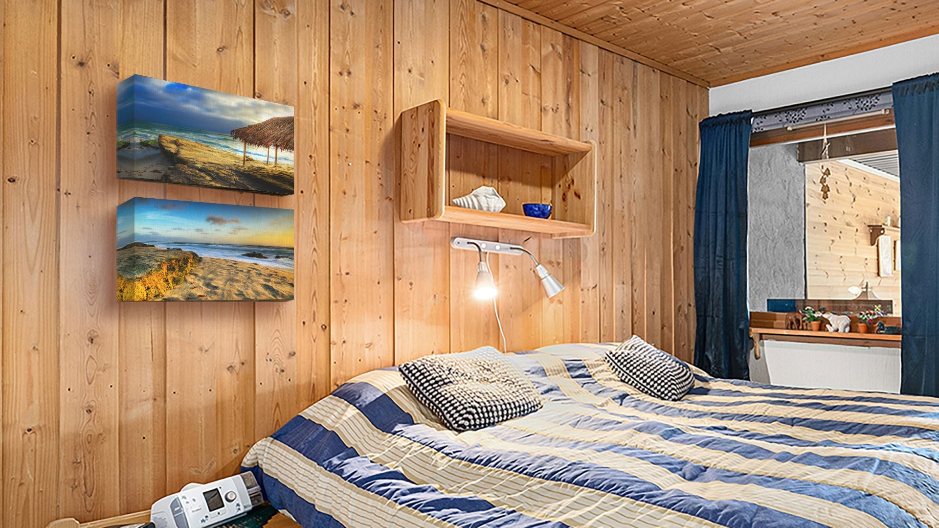 A seaside bedroom with light wood walls and blue and white furniture. Two canvas photographs of Windansea Beach hang on the wall.