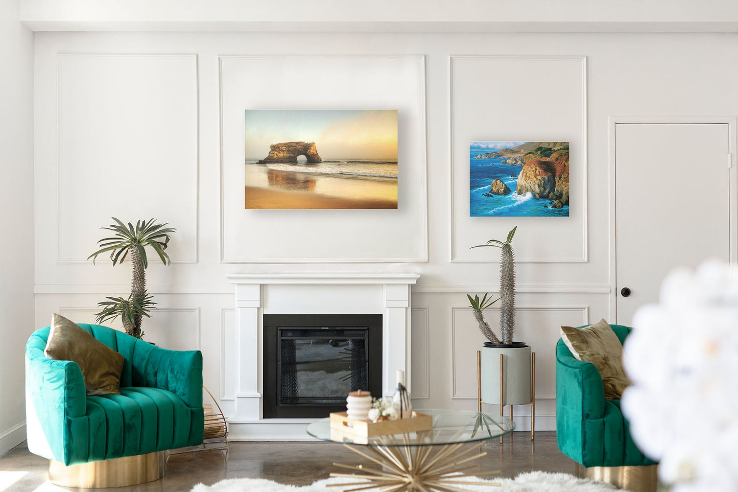 A tropical sea themed living room with highly designed white walls and teal furniture. Two canvas artworks hang on the wall– a photograph of Natural Bridges in Santa Cruz, California, and a painting of the view from Rocky Point at Big Sur, CA.