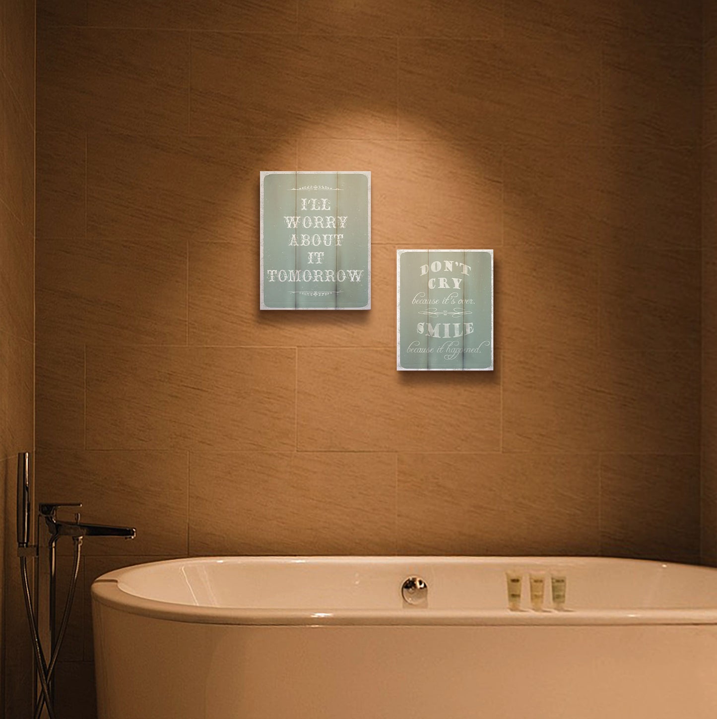 Two artworks hanging on a bathroom wall. The first is a typography design reading "I'll worry about it tomorrow" in white on a pale blue background. Printed on a box board. The second is a typography design reading "Don't cry because it's over, smile because it happened" in white on a blue background. Printed on a box board.