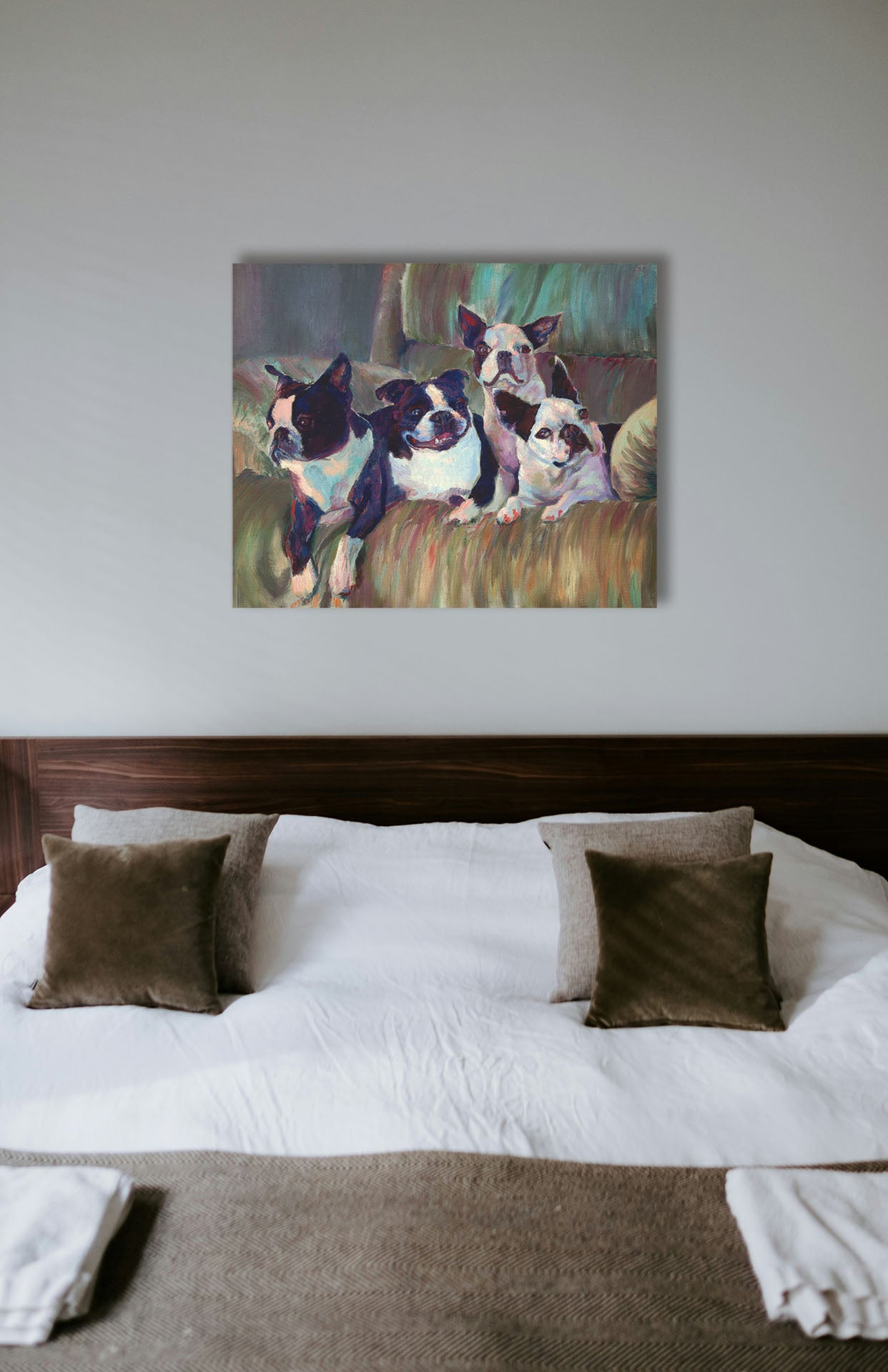 A painting hanging on a bedroom wall. A painting of four Boston terriers, posed lying in a light brown armchair. Printed on canvas.