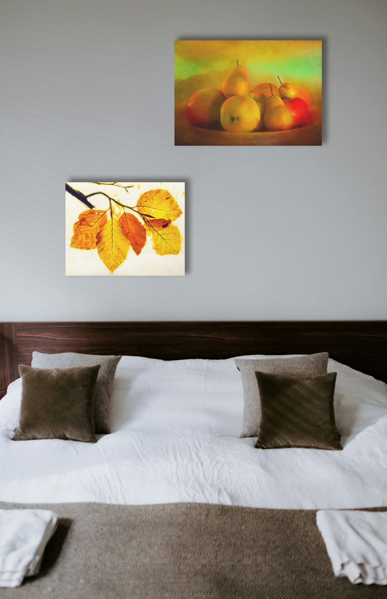 Two paintings hanging on a bedroom wall. The first is a photo of a dish of apples and pears, in a greenish yellow light. Printed on canvas. The second is a photo of a twig of orange and yellow leaves on a white background. Printed on canvas.