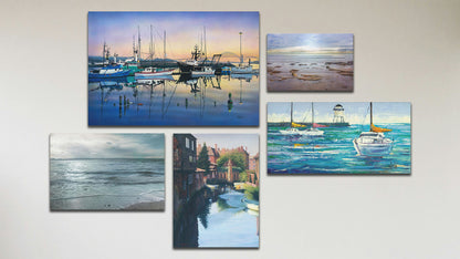 A collage of art in the standard Tranquil Harbor package, including three canvas paintings of sailboats at the harbor, sailboats on the sea, and Canterbury Canal in England; a canvas photograph of the sea from the beach; and a box board photograph of the North Sea.