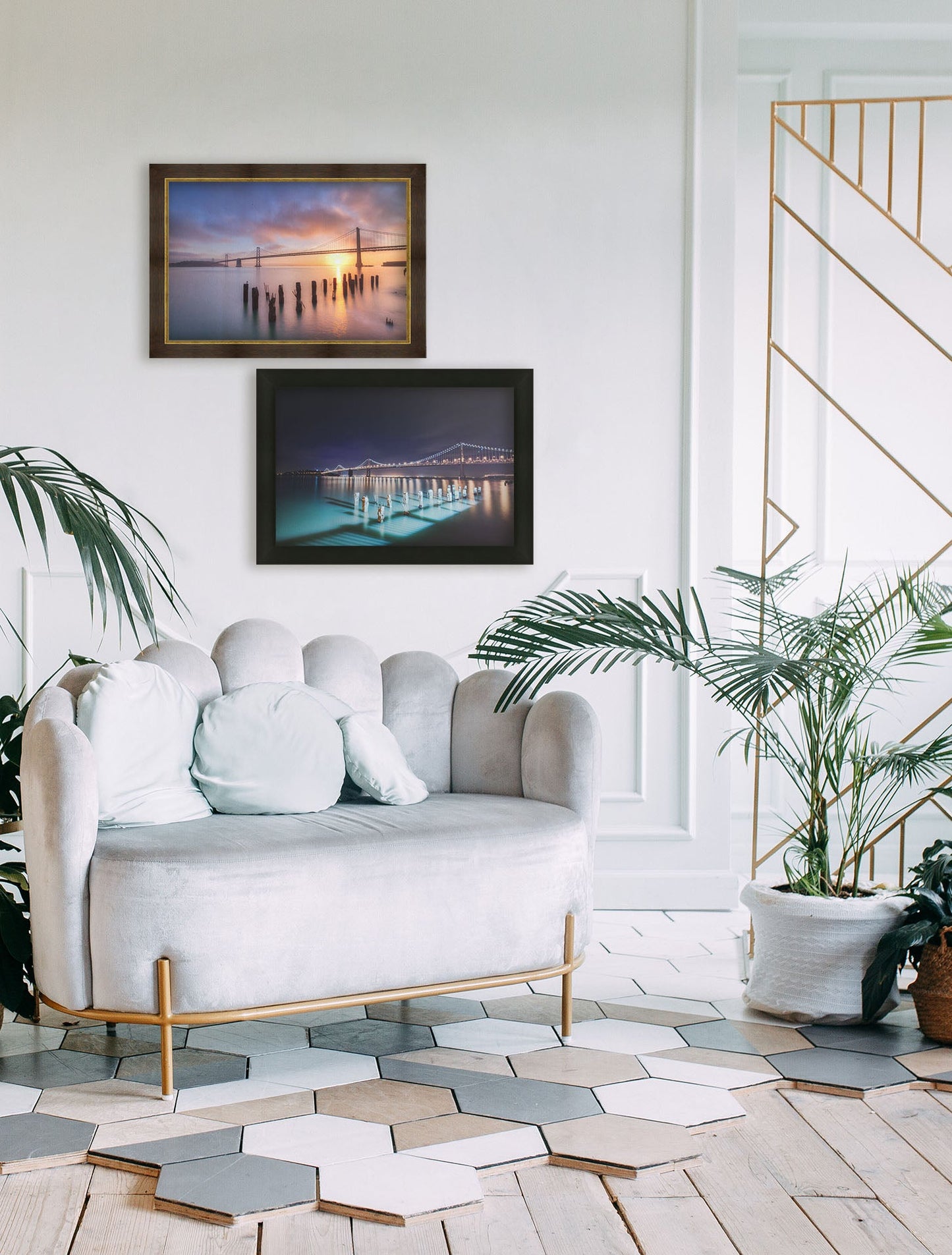 A tropical sea themed living room with palm plants and shell-themed furniture. Two framed photographs overlooking the bridges of San Francisco at day and night hang on the wall.