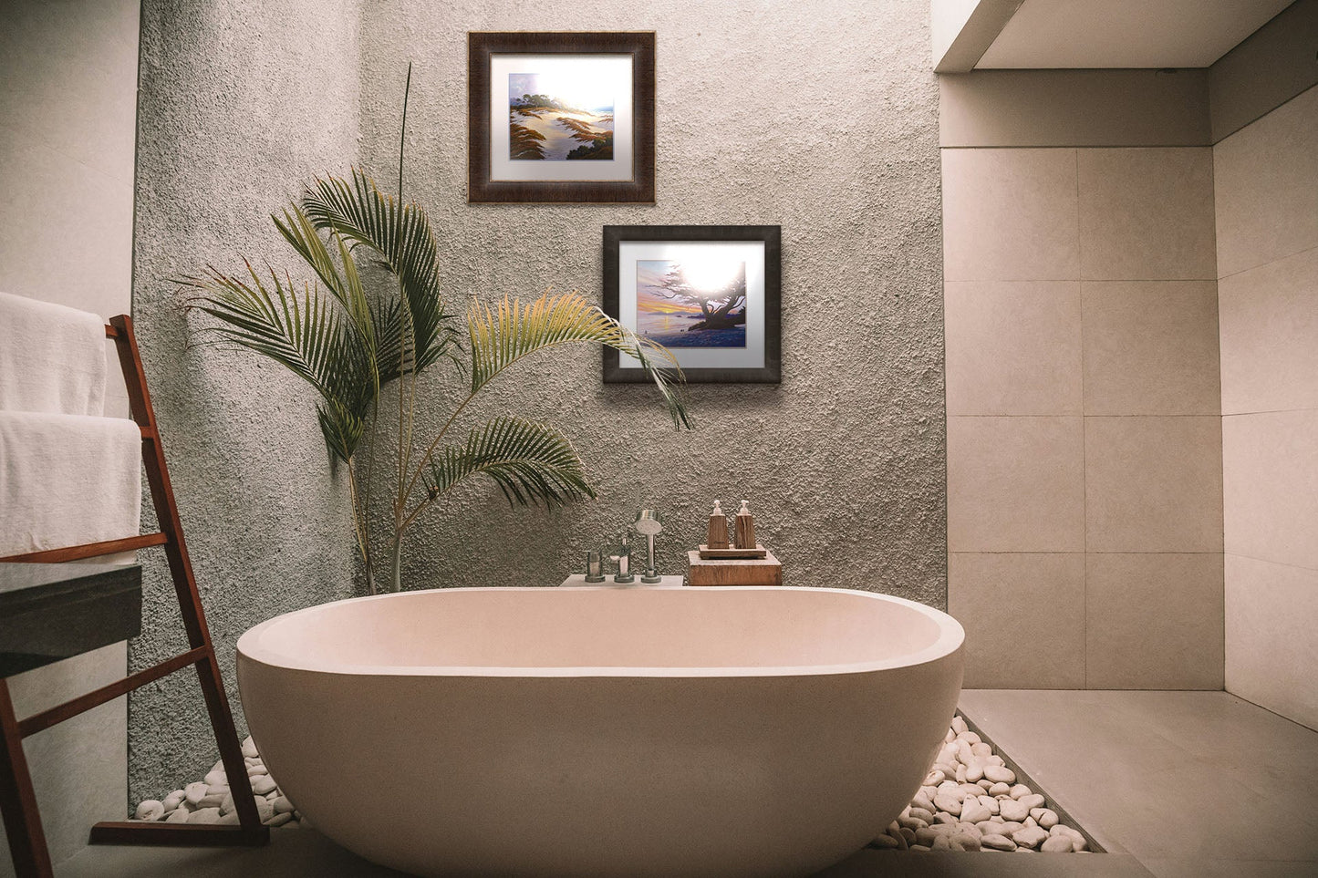 A tropical sea themed bathroom with palm plants and a large tub. Matted and framed paintings of Caramel Beach, California, and Asilomar Beach, California, hang on the wall.