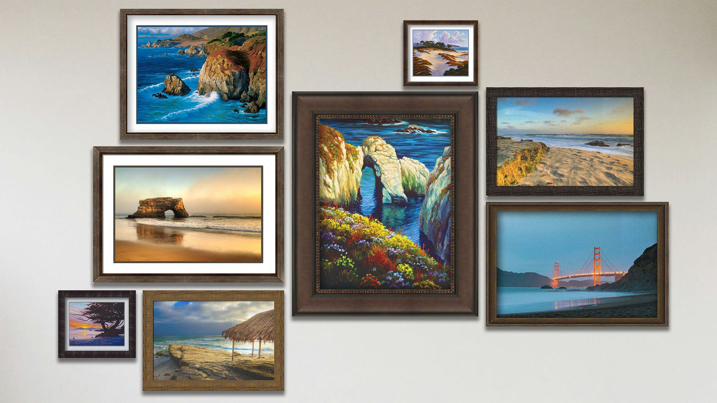 A collage of art in the designer Santa Cruz Natural Bridges package, including two framed photographs of Windansea Beach, La Jolla, California; a framed photograph of Baker Beach; a matted and framed photograph of the Santa Cruz Natural Bridges; a framed painting of Point Lobos; and three matted and framed paintings of Caramel Beach, Big Sur, and Asilomar, California.