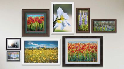 A collage of art in the designer Tangerine Dream package, including two matted and framed paintings of poppy flowers, two framed paintings of lupine plants, a framed photograph of yellow flowers in Arizona, a framed photograph of white plumeria flowers, a matted and framed painting of a person picnicking by a lake, and a matted and framed painting of a swan.