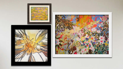 A collage of art in the designer Under the Sun package, including a matted and framed painting of a pond of water lilies in arbitrary colors, a framed painting of a contemporary, abstracted flower garden, and a framed photograph of a daisy closeup.