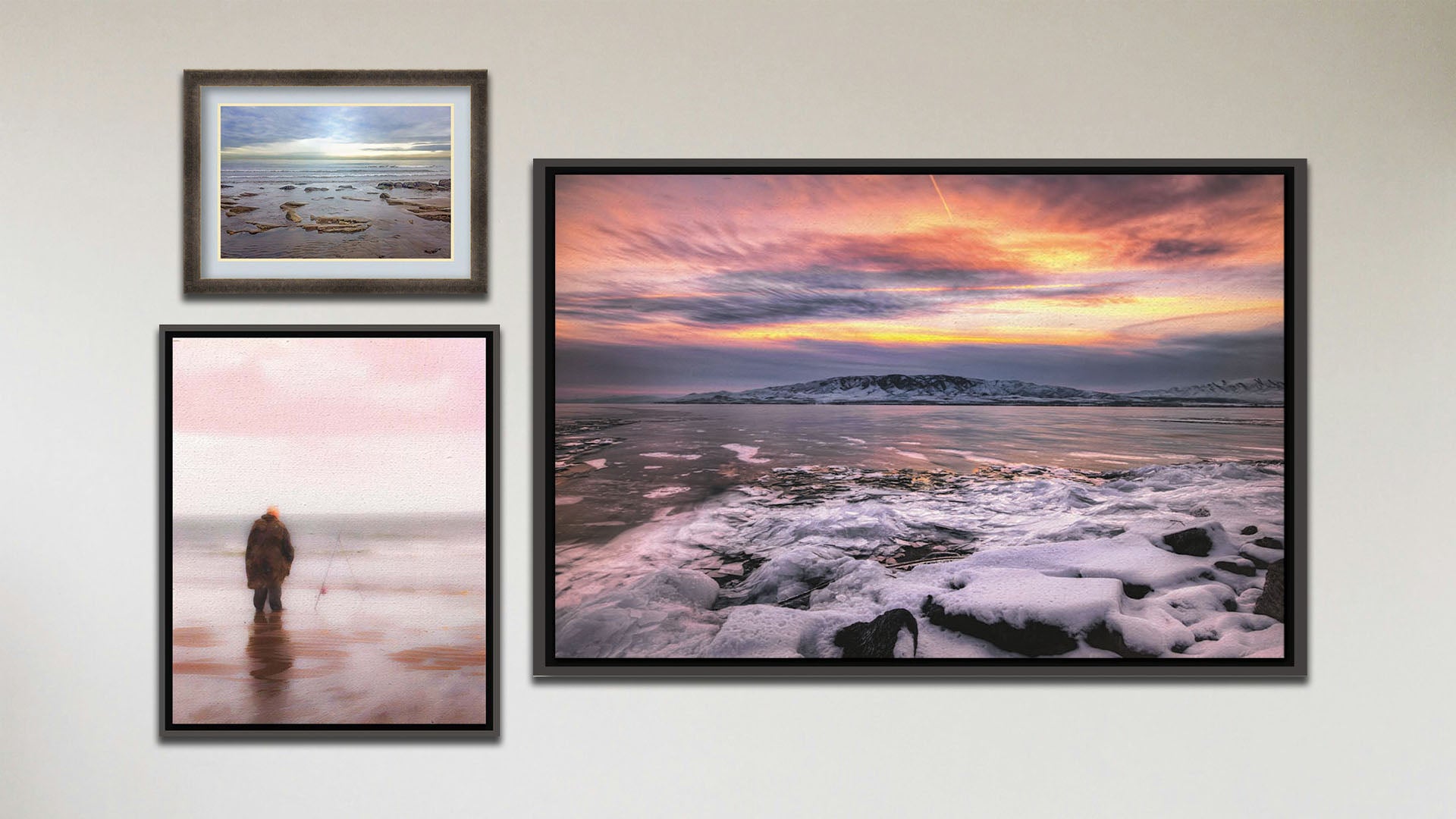 A collage of art in the luxury Tranquil Harbor package, including a float framed photograph of a sunset over a snowy shore, a float framed photograph of a fisherman watching their line in the ocean shallows, and a matted and framed painting of a person fishing on an icy shore.