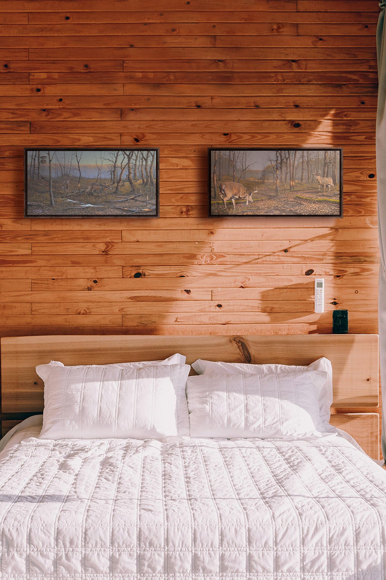 Two paintings hang on a bedroom wall. The first is a painting of deer walking through the forest in winter, with turkeys wandering through the background. The trees are bare, and brown leaves cover much of the ground. Hunting stands can be seen in the distance. Printed on canvas in a float frame. The second is a painting of two deer approaching each other in the woods. The two bucks are about to fight, as is evident by their body language. Printed on canvas in a float frame.