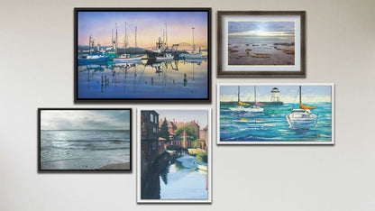 A collage of art in the luxury Tranquil Harbor package, including three float framed paintings of sailboats at the harbor, sailboats on the sea, and Canterbury Canal in England; a float framed photograph of the sea from the beach; and a matted and framed photograph of the North Sea.